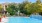 a swimming pool with trees and a house in the background