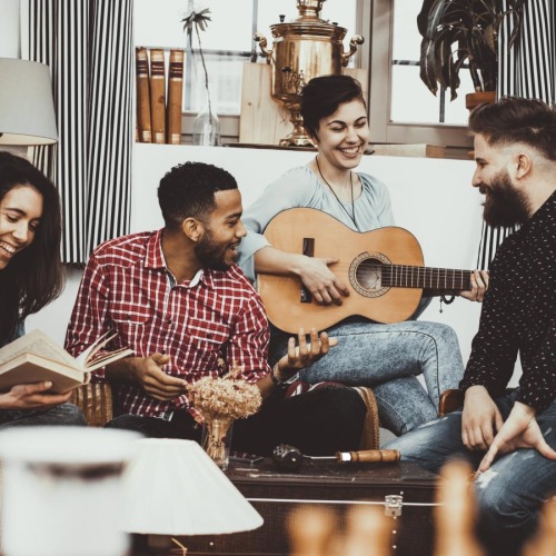 a group of people sitting on a couch playing a guitar