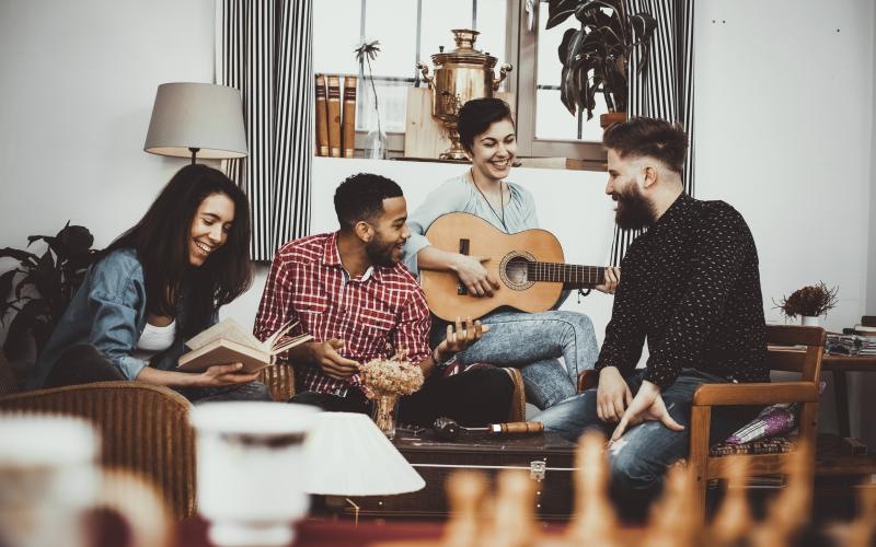 a group of people sitting on a couch playing a guitar