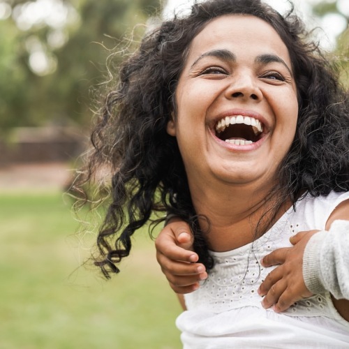 a woman carrying her daughter in an open field