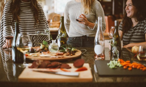 a group of women at a table with food and drinks