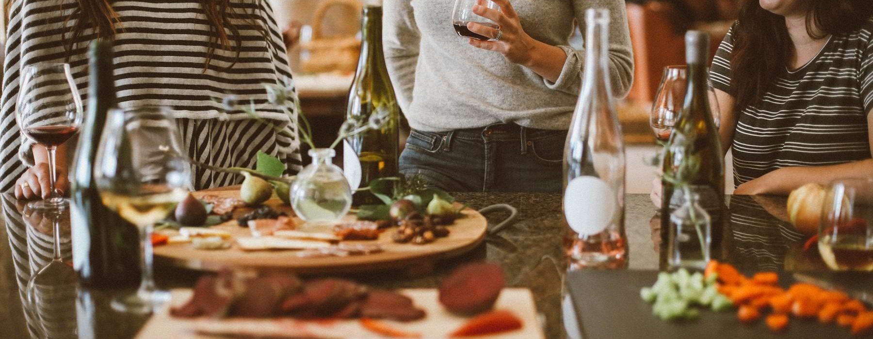 a group of women at a table with food and drinks