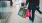 a man walking in a mall with shopping bags and a camera