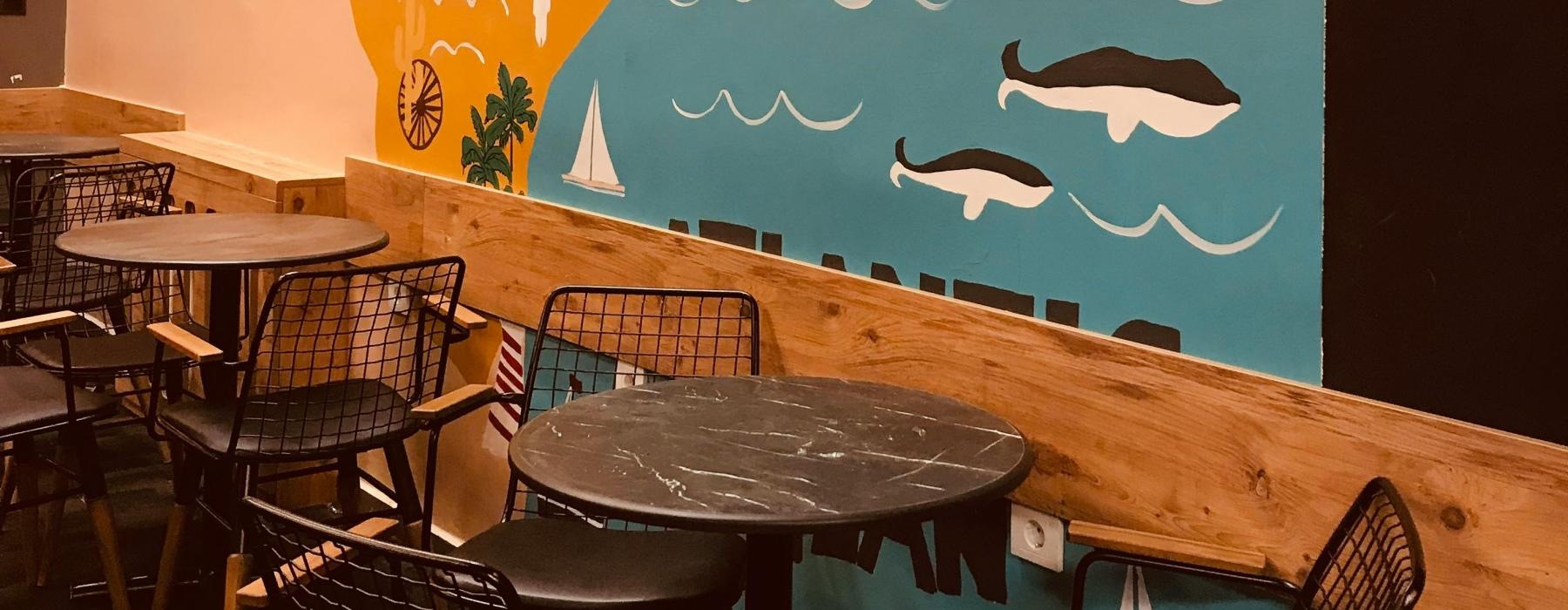 table and chairs by a wall painting